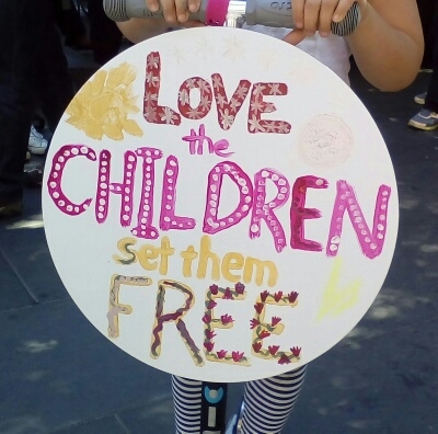 'Love the children and set them free', appended to front of a scooter ridden by the artist (colouring in), 2015.